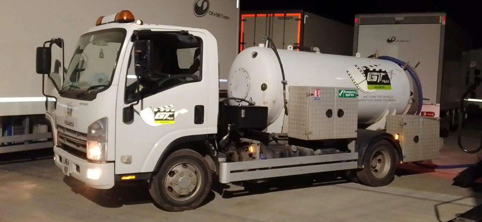 A white truck parked next to a train.